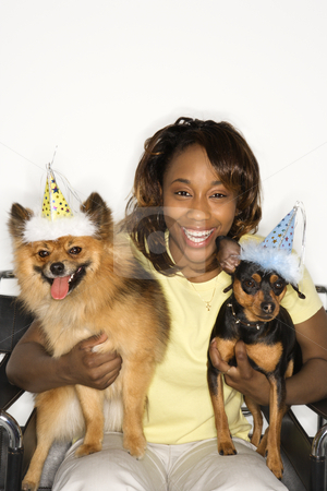 To use this stock image in your creative project, please select the size you need over to the right and click the "Add to Cart" button.
Your downloaded image will come with the Cutcaster watermark removed so don’t worry about the watermark you see on this page. Woman holding dogs in party hats. stock photo, African American young adult female holding brown Pomeranian and Miniature Pinscher dogs wearing party hats. by Iofoto Images