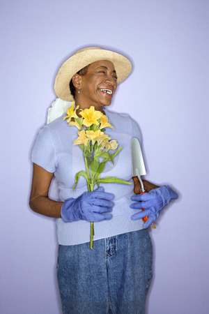 To use this stock image in your creative project, please select the size you need over to the right and click the "Add to Cart" button.
Your downloaded image will come with the Cutcaster watermark removed so don’t worry about the watermark you see on this page. Happy gardener woman. stock photo, African American mature adult female with hand shovel and flowers. by Iofoto Images