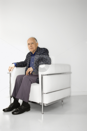 Man sitting in chair. Man sitting in chair. stock photo, Caucasian mature adult male sitting in chair looking at viewer. by Iofoto Images