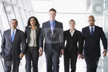 Group of business people walking towards camera Group of business people walking towards camera stock photo, Group of business people walking through office towards camera by Monkey Business Images
