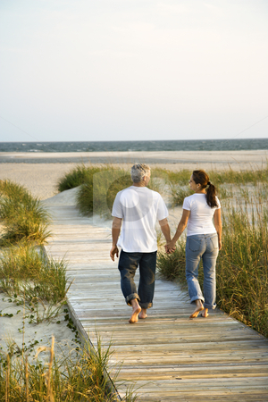 To use this stock image in your creative project, please select the size you need over to the right and click the "Add to Cart" button.
Your downloaded image will come with the Cutcaster watermark removed so don’t worry about the watermark you see on this page. Couple at beach. stock photo, Back view of mid-adult Caucasian couple walking down walkway to beach. by Iofoto Images