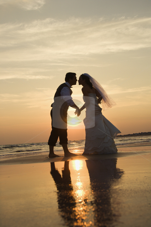 To use this stock image in your creative project, please select the size you need over to the right and click the "Add to Cart" button.
Your downloaded image will come with the Cutcaster watermark removed so don’t worry about the watermark you see on this page. Bride and groom kissing. stock photo, Caucasian prime adult male groom and female bride holding hands and kissing barefoot on beach at sunset. by Iofoto Images