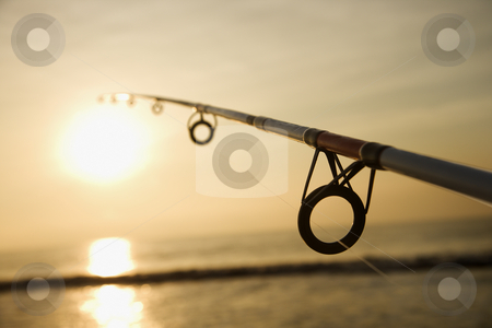 Fishing pole at sunset. Fishing pole at sunset. stock photo, Fishing pole against ocean at sunset. by Iofoto Images