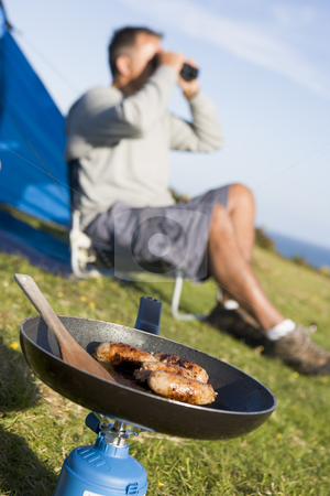 To use this stock image in your creative project, please select the size you need over to the right and click the "Add to Cart" button.
Your downloaded image will come with the Cutcaster watermark removed so don’t worry about the watermark you see on this page. Man camping outdoors and cooking stock photo, by Monkey Business Images