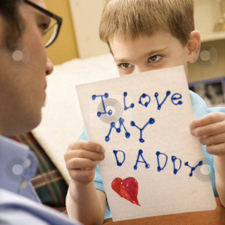 Boy giving dad drawing. Boy giving dad drawing. stock photo, Caucasian boy giving mid adult father a drawing. by Iofoto Images