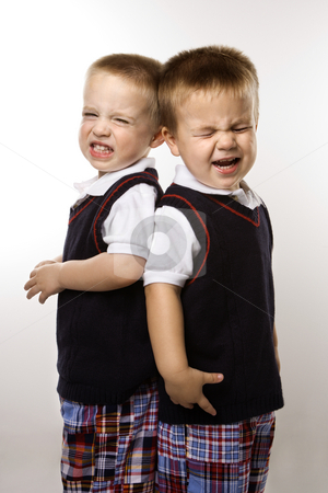 Twin boy brothers crying. Twin boy brothers crying. stock photo, Caucasian twin boys crying standing against white background. by Iofoto Images