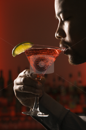 To use this stock image in your creative project, please select the size you need over to the right and click the "Add to Cart" button.
Your downloaded image will come with the Cutcaster watermark removed so don’t worry about the watermark you see on this page. Man drinking martini. stock photo, African American man drinking martini in bar against glowing red background. by Iofoto Images