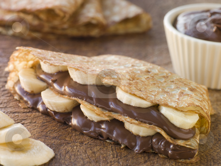 To use this stock image in your creative project, please select the size you need over to the right and click the "Add to Cart" button.
Your downloaded image will come with the Cutcaster watermark removed so don’t worry about the watermark you see on this page. Crepes filled with Banana and Chocolate Hazelnut Spread stock photo, by Monkey Business Images