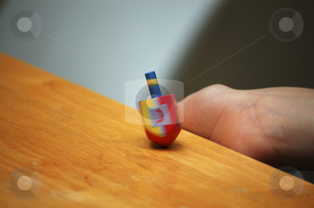 Child spinning a dreidel during Hanukkah Child spinning a dreidel during Hanukkah stock photo, by Heather Shelley