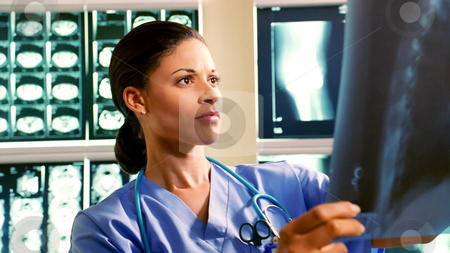 Medical Professional Medical Professional stock photo, A medical professional examines an x-ray. by Jordan Edgcomb