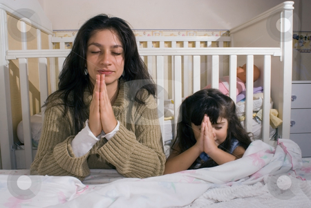 Mother Mother stock photo, Mother and daughter saying their prayers together before going to bed by Orange Line Media