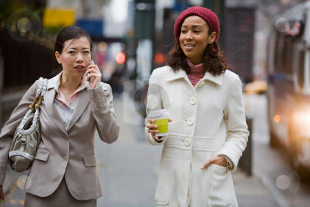 City Business Women City Business Women stock photo, Two business women walking in the big city. One is on her cell phone. by Todd Arena