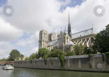Notre Dame and the Seine Notre Dame and the Seine stock photo, The Notre Dame in Paris, on ile de la Cit? seen from the opposite side of the river Seine. A river boat takes the tourists past all the sites; the sun strikes the roof tops of the cathedral beautifully by Corepics VOF