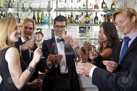 Toasting on a new Years Eve Party Toasting on a new Years Eve Party stock photo, Several people toasting with champagne on new years eve while holding sparkling sticks by Corepics VOF