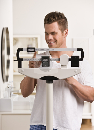 To use this stock image in your creative project, please select the size you need over to the right and click the "Add to Cart" button.
Your downloaded image will come with the Cutcaster watermark removed so don’t worry about the watermark you see on this page. Attractive male on scale. stock photo, Attractive male weighing himself on scale and smiling. Vertical by Jonathan Ross
