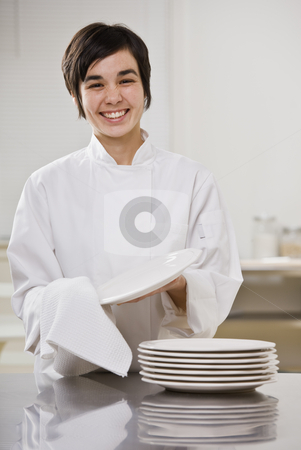 Smiling brunette drying dishes. Smiling brunette drying dishes. stock photo, Smiling brunette woman drying dishes, smiling at camera. Vertical. by Jonathan Ross