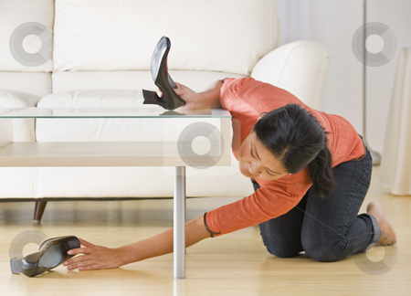 To use this stock image in your creative project, please select the size you need over to the right and click the "Add to Cart" button.
Your downloaded image will come with the Cutcaster watermark removed so don’t worry about the watermark you see on this page. Asian woman reaching for shoe. stock photo, Asian woman kneeling on floor and reaching for shoe under coffee table. Horizontal. by Jonathan Ross