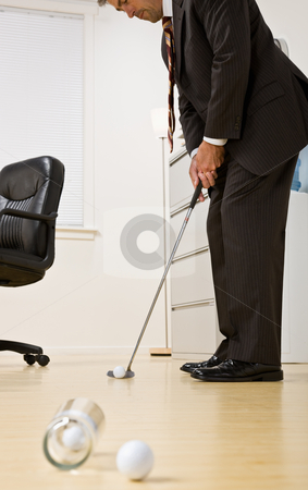Businessman putting golf ball in office Businessman putting golf ball in office stock photo, Businessman putting golf ball in office by Jonathan Ross