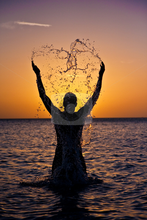 To use this stock image in your creative project, please select the size you need over to the right and click the "Add to Cart" button.
Your downloaded image will come with the Cutcaster watermark removed so don’t worry about the watermark you see on this page. Heart-Shaped Splash stock photo, Man splashes in the water, silhoutted at sunset. by Tyson Koska