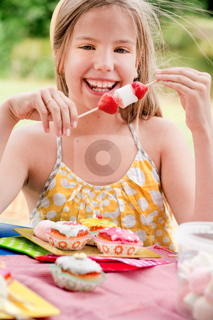 Smiling girl and a stick full of marshmallows Smiling girl and a stick full of marshmallows stock photo, Teenagers having a great time in the park by Frenk and Danielle Kaufmann