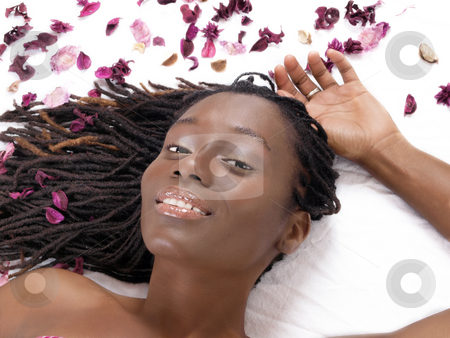 To use this stock image in your creative project, please select the size you need over to the right and click the "Add to Cart" button.
Your downloaded image will come with the Cutcaster watermark removed so don’t worry about the watermark you see on this page. Young black woman reclining on sheet with flower petals stock photo, Young smiling african american woman reclining with flower parts by Jeff Cleveland