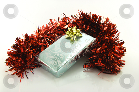 To use this stock image in your creative project, please select the size you need over to the right and click the "Add to Cart" button.
Your downloaded image will come with the Cutcaster watermark removed so don’t worry about the watermark you see on this page. Silver Wrapped Gift with Tinsel stock photo, Single shiny silver wrapped gift with gold bow and red tinsel on reflective white background by Keith Wilson