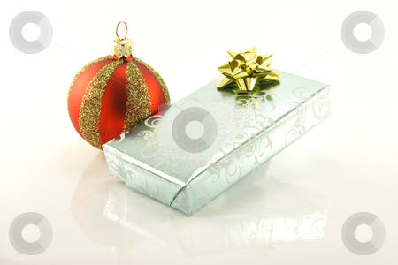 Silver Gift and Bauble Silver Gift and Bauble stock photo, Single shiny silver wrapped gift with a red and gold bauble on a reflective white background by Keith Wilson