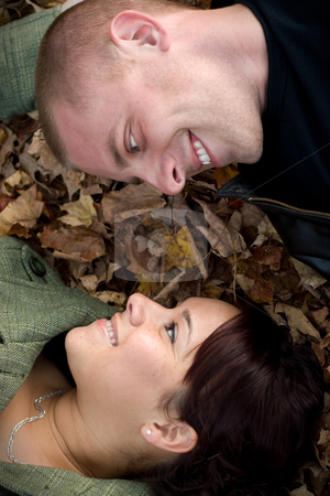 To use this stock image in your creative project, please select the size you need over to the right and click the "Add to Cart" button.
Your downloaded image will come with the Cutcaster watermark removed so don’t worry about the watermark you see on this page. Young Couple In Love stock photo, A young happy couple gazing into each others eyes while laying in a pile of leaves. by Todd Arena