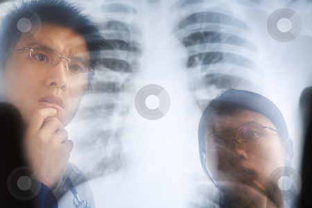 Asian doctor examining xray negative Asian doctor examining xray negative stock photo, Asian doctor examining xray negative / roentgen print. PS:the image taken from behind the xray print, so it may leave some soft noise on the people image behind it. by Rudyanto Wijaya