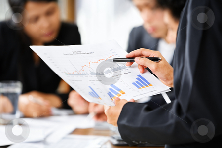 Examining graphs with other people on background Examining graphs with other people on background stock photo, Businesswoman examining graphs with other working people on background by Rudyanto Wijaya