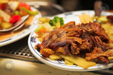 Plate of Chinese fried duck on a burner Plate of Chinese fried duck on a burner stock photo, Plate of Chinese Fried Duck. A Chinese food dish of fried noodles with sweet and sour sauce, salad, and pieces of cheese as well as some vegetables like onions and carrots. Image taken inside a Chinese restaurant. by Sean Nel