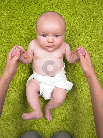 Baby Lying on Floor With Hands Held by Parent Baby Lying on Floor With Hands Held by Parent stock photo, Baby lying on floor with adult holding hands. Vertically framed shot. by Mog Ddl