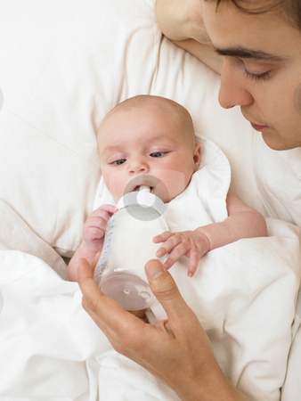 To use this stock image in your creative project, please select the size you need over to the right and click the "Add to Cart" button.
Your downloaded image will come with the Cutcaster watermark removed so don’t worry about the watermark you see on this page. Father Feeding Baby stock photo, Father feeding baby while in bed. Vertically framed shot. by Mog Ddl