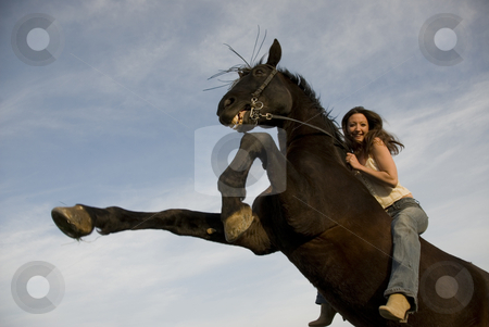 To use this stock image in your creative project, please select the size you need over to the right and click the "Add to Cart" button.
Your downloaded image will come with the Cutcaster watermark removed so don’t worry about the watermark you see on this page. Happy girl and rearing stallion stock photo, Happy girl and rearing stallion in blue sky by Bonzami Emmanuelle