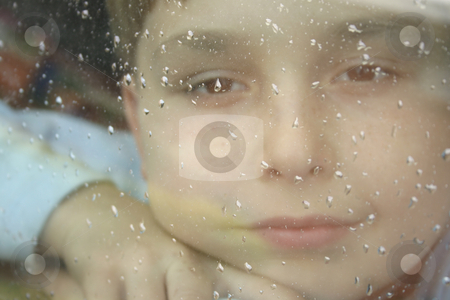 Rainy Daze - boy looks out of a window Rainy Daze - boy looks out of a window stock photo, Boy behind a window pane covered with raindrops on a rainy day daydreams by Leah-Anne Thompson