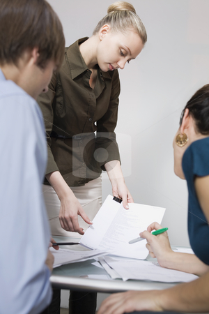 Businesspeople with Paperwork Businesspeople with Paperwork stock photo, Businesspersons discussing paperwork. Vertically framed shot. by Sean De Burca