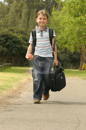 Back to School Back to School stock photo, Boy walking to school. He has a backpack, carrying a small portable computer and is holding an apple in his hand by Leah-Anne Thompson