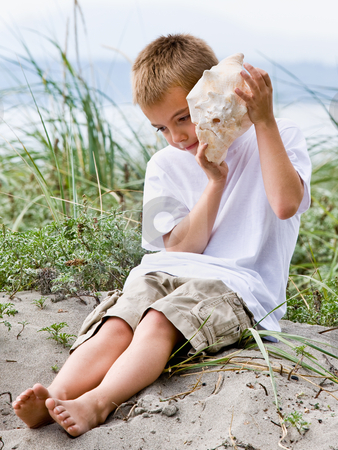 To use this stock image in your creative project, please select the size you need over to the right and click the "Add to Cart" button.
Your downloaded image will come with the Cutcaster watermark removed so don’t worry about the watermark you see on this page. Boy listening to seashell at beach stock photo, Boy listening to seashell at beach by Jonathan Ross