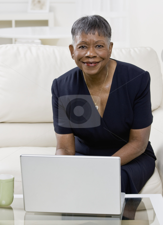 Older African American Woman Smiling Older African American Woman Smiling stock photo, Older African American woman with laptop, smiling at camera. Vertically framed shot. by Jonathan Ross