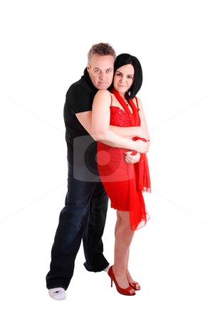 Couple hugging. Couple hugging. stock photo, An middle age couple, she in an red dress and black hair get a big hug
from her husband from the back, on white background. by Horst Petzold