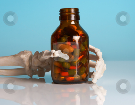 Last medicine Last medicine stock photo, Skeleton hand holding a brown bottle full of pills by Anneke