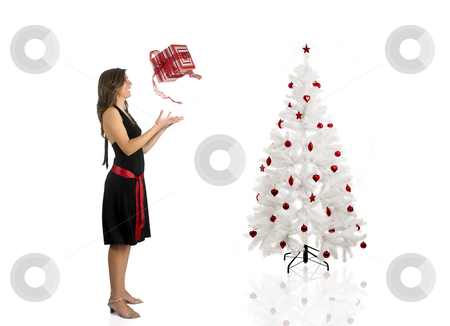 Happy woman with a gift Happy woman with a gift stock photo, Beautiful Woman wiht a gift and a Christmas tree by ikostudio