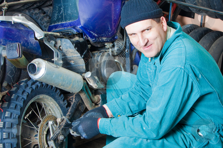 Mechanic in garage Mechanic in garage stock photo, Mechanic changing car tire in garage by Ruta Balciunaite