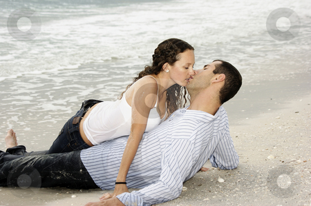 To use this stock image in your creative project, please select the size you need over to the right and click the "Add to Cart" button.
Your downloaded image will come with the Cutcaster watermark removed so don’t worry about the watermark you see on this page. Wet young adult couple kissing at the beach stock photo, A young american couple are on the beach kissing, the woman is on top of the man by Stephen Orsillo
