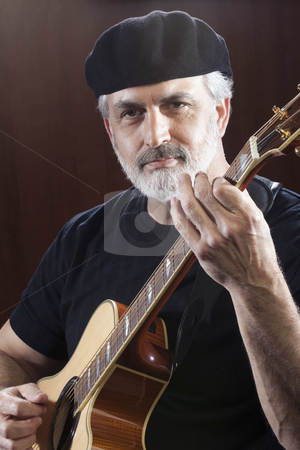 To use this stock image in your creative project, please select the size you need over to the right and click the "Add to Cart" button.
Your downloaded image will come with the Cutcaster watermark removed so don’t worry about the watermark you see on this page. Middle-Aged Man With Acoustic Guitar stock photo, Portrait of a middle-aged man wearing a black beret and t-shirt and playing an acoustic guitar. He is looking at the camera. Vertical shot. by Edward Bock