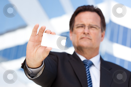 Handsome Businessman Holds Out Blank Business Card Handsome Businessman Holds Out Blank Business Card stock photo, Handsome Businessman in Suit and Tie Holds Out Blank Business Card in Front of Corporate Building. by Andy Dean