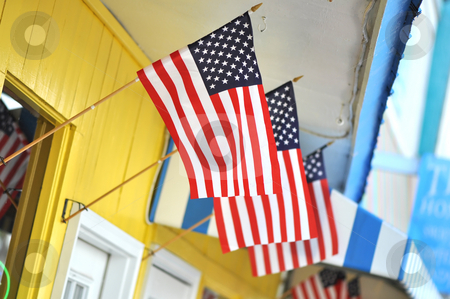 To use this stock image in your creative project, please select the size you need over to the right and click the "Add to Cart" button.
Your downloaded image will come with the Cutcaster watermark removed so don’t worry about the watermark you see on this page. Store Front with American Flags stock photo, Colorful store front with three American flags flying. by Danny Hooks
