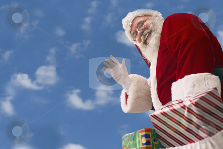 Santa Claus against a baby blue sky Santa Claus against a baby blue sky stock photo, Santa Claus with bag of presents waves against a background of Cumulus clouds in an azure blue sky by Gabe Palmer