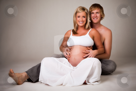Young Pregnant Couple Smiling stock photo, A young pregnant couple is ... Young Pregnant Couple Smiling stock photo, A young pregnant couple is ...