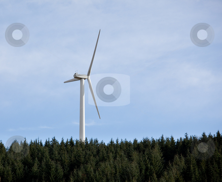 Single wind electricity generator Single wind electricity generator stock photo, Large wind based electricity turbine rising above the tree line against a blue sky by Steven Heap
